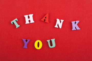 THANK YOU word on red background composed from colorful abc alphabet block wooden letters, copy...