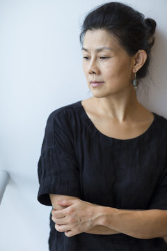 portrait of senior asain woman leaning on wall