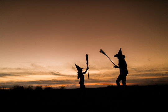mother with daughter playing at halloween night