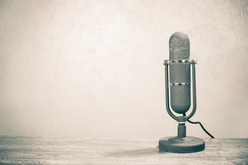 Old retro studio microphone from 50s on table. Vintage style sepia photo