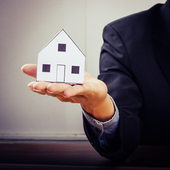 Businessman holding paper home model. Loan concept