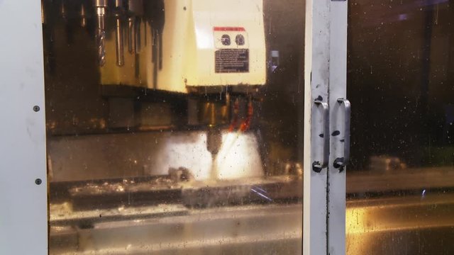Industrial drill through glass door in factory