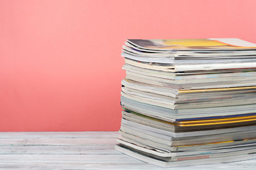 Open stacking book, magazine hardback colorful books on wooden table and red, pink background. Back to school. Copy space for text. Education business concept.