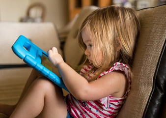 Preschool girl using a tablet computer at home