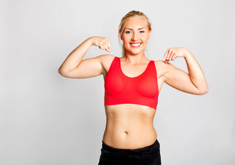 Fototapeta na wymiar Young woman showing biceps