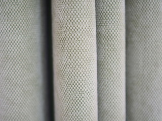 Light pale green folded curtain fabric texture, close up shot