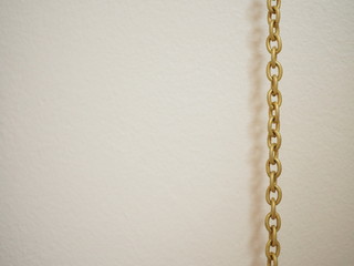 Gold metal chain string hanging on the right, with blank pink painted wall background