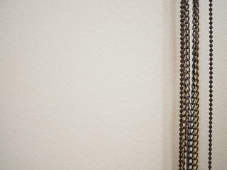Mix gold and black chain strings hanging on the right, with blank pink wall background