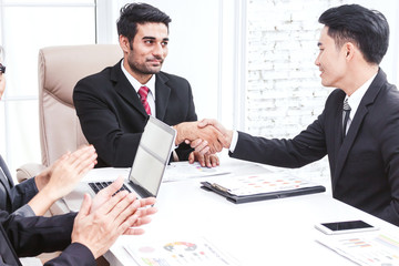 Business partners shaking hands in office