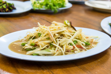Papaya salad on wooden table