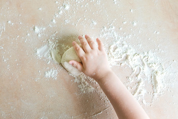 Fototapeta premium Children's hands make dough