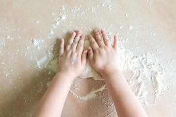 Children's hands make dough