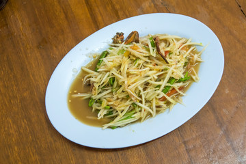 Papaya salad on wooden table