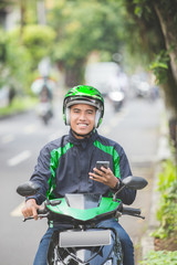 motorcycle taxi driver taking order via mobile phone online app