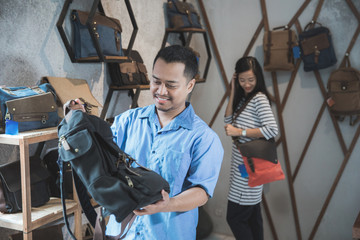 man trying a new bag at a shop