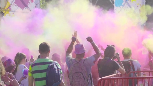Holi Color Festival. Crowd of people throws into the air a large amount of colored powder