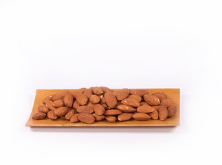 Almond nuts in wooden bowl isolated on white background with clipping path.