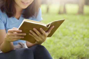Fototapeta na wymiar Asian woman in Blue shirt reading a book.