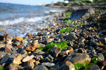 Pebble stones near the sea in bright sunset light