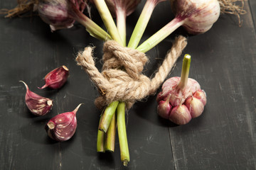 Fresh garlic, vegetables on black wooden background
