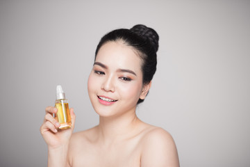 Beauty concept. Asian pretty woman with perfect skin holding oil bottle