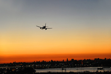 Fototapeta na wymiar airplane on the colorful sunset sky in New York