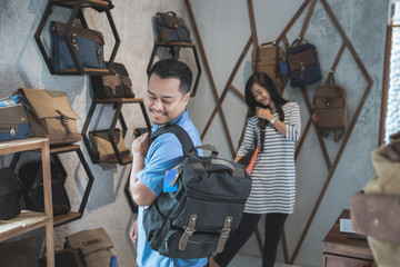 man trying a new bag at a shop