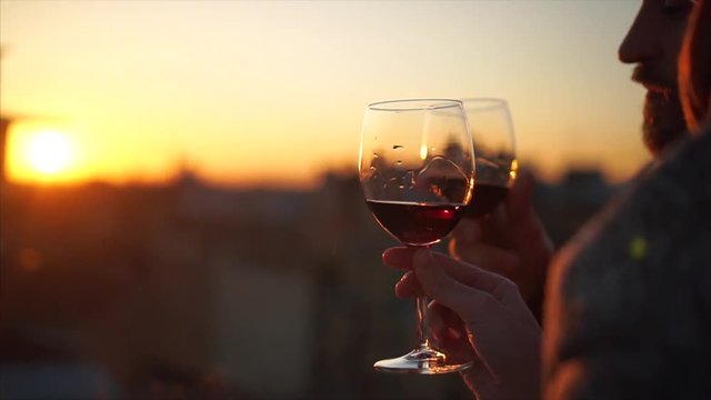 Two Hands and wineglass silhouette on sunset.