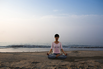 Fototapeta na wymiar Yoga girl on the beach