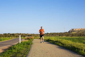 Fototapeta premium Athletic young man running in the nature. Healthy lifestyle.