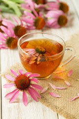 Cup of echinacea tea on white wooden table