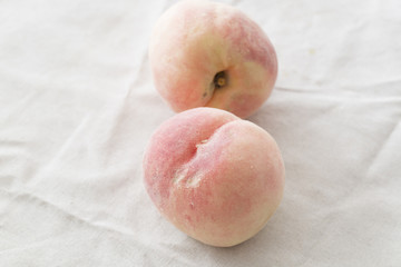 Two fresh peaches on the table.
