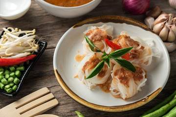 Noodle and fish curry sauce with ingredient on black table.