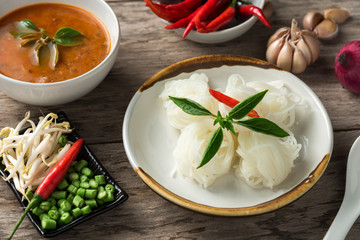 Noodle and fish curry sauce with ingredient on black table.