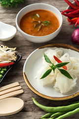 Noodle and fish curry sauce with ingredient on black table.