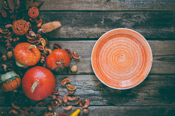 orange enamelled clay plate on autumn decorated wooden table,  top view - 167878214