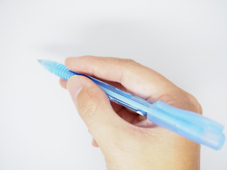 Right hand holding blue ballpoint pen, white background