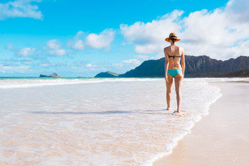 Fototapeta na wymiar woman walking on white sand beach 
