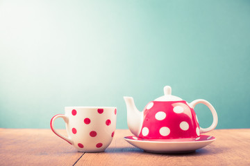 Cup of tea and teapot with polka dots. Retro style filtered photo