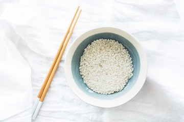 Schüssel mit Reis und daneben Stäbchen