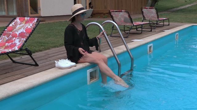 Woman is splashing in the pool by water