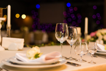 Beautiful table setting with crockery and flowers for a party, wedding reception or other festive event. Glassware and cutlery for catered event dinner.