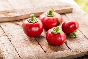 Fresh sweet red pepper on old wooden background.