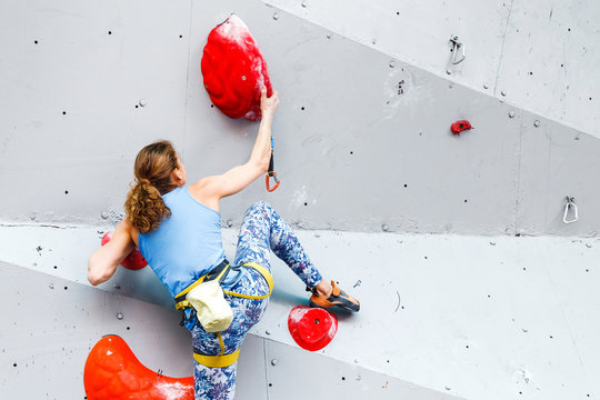 active young and fit woman on artificial climbing rock wall in extreme sport center