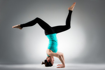 young fitness gymnastic woman handstand on floor