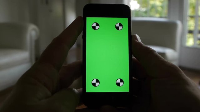 Smart Phone held by hands. Green screen Chroma Key. Close up. Tracking motion. Vertical.