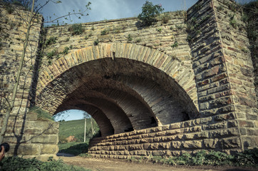 View of the arcs of the old historic stone bridge