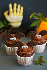 Chocolate muffins, with a chocolate cream in the form of bat on Halloween.