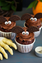 Chocolate muffins, with a chocolate cream in the form of bat on Halloween.