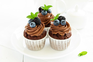 Chocolate cupcakes, with chocolate cream and fresh berries.